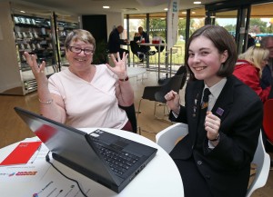 Beth Anderson, 15, shows Jean Handley how to access online services 